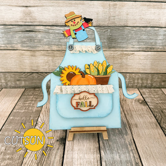 Laser-cut fall shelf sitter SVG add-on featuring scarecrow, pumpkin, corn and sunflower in an apron design – for interchangeable apron base.