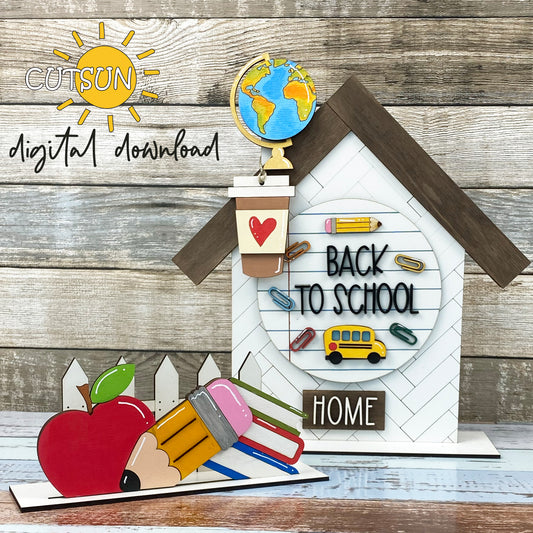 A digital download image featuring a back to school themed decoration, including a house with a chimney, fence stand, and various school-related items like a notebook, pencil, and apple.