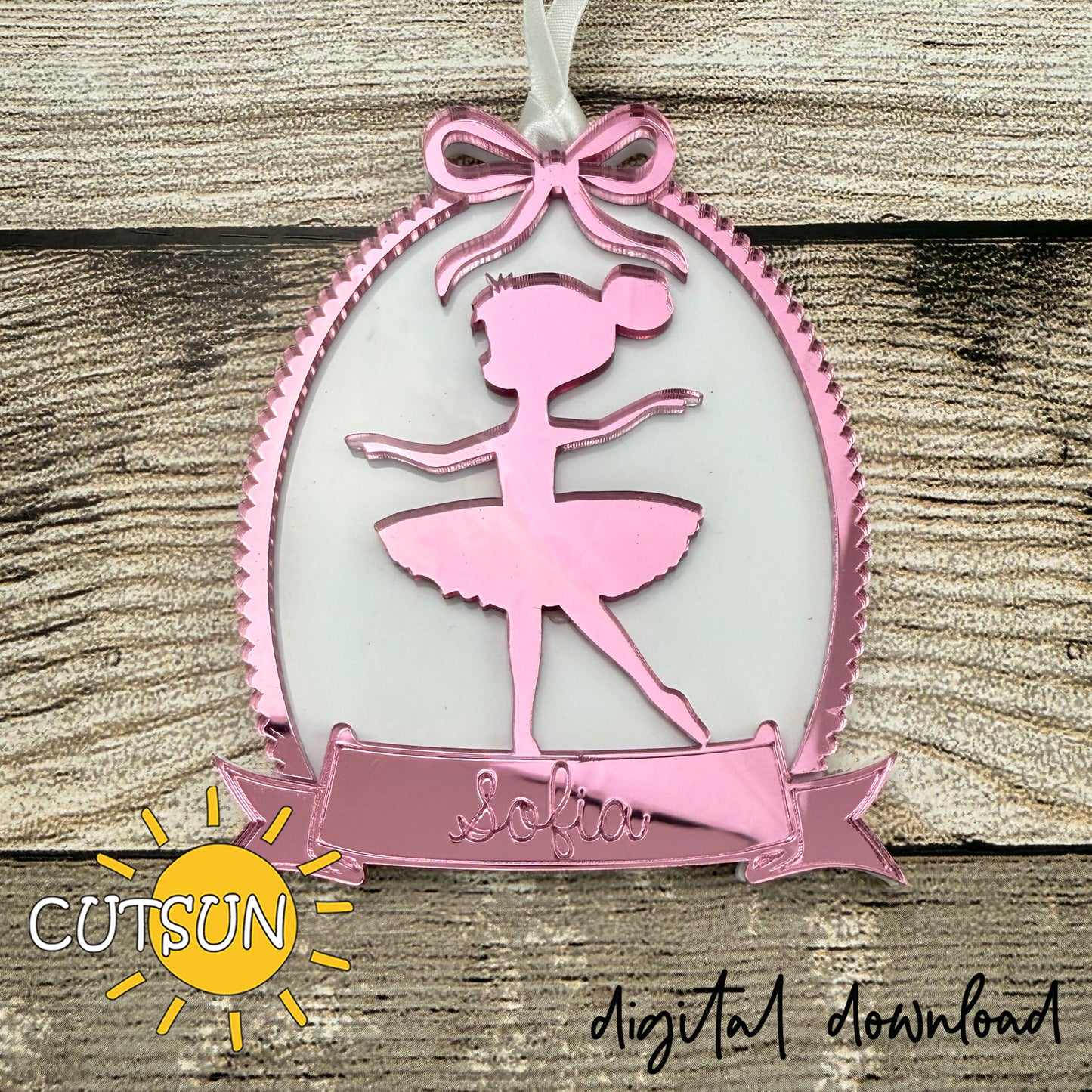 Pink ballerina ornament with ribbon frame and personalized name banner, designed for laser cutting.