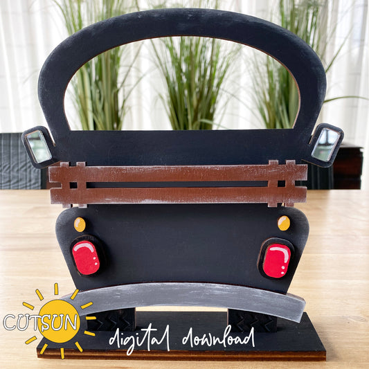 A digital representation of a Farmhouse truck SVG file which appears as a black silhouette with decorative elements like a front grill, wheels, and red accents.