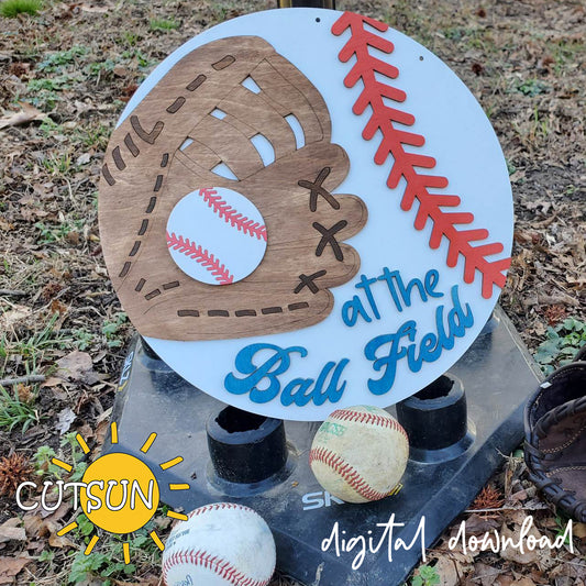 Digital download featuring a round door hanger with a baseball glove, a baseball, and the text 'at the Ball field'.