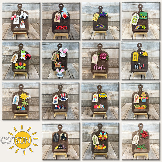 A collection of 15 interchangeable cutting board designs in SVG format, each with a holiday or seasonal theme displayed on a wooden background.