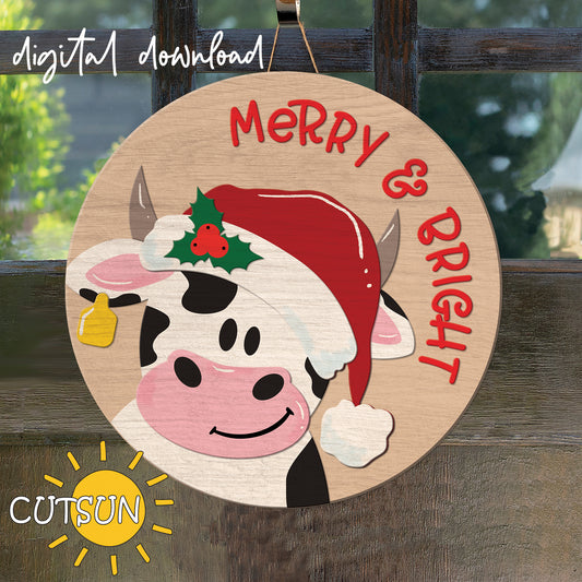 A digital image showing a circular Christmas door hanger with a cartoon depiction of a dairy cow wearing a Santa hat and the text 'Merry and Bright'.