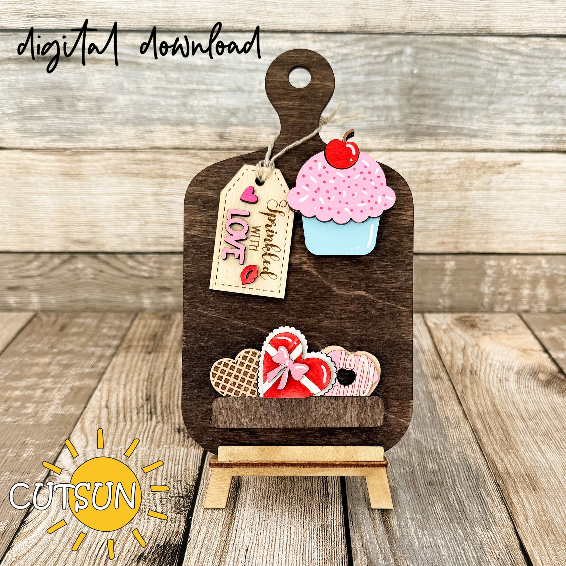 A digital download image showing a wooden cutting board decorated with a cupcake, heart-shaped waffle, box of chocolates, and a doughnut, adorned with love-themed tags.