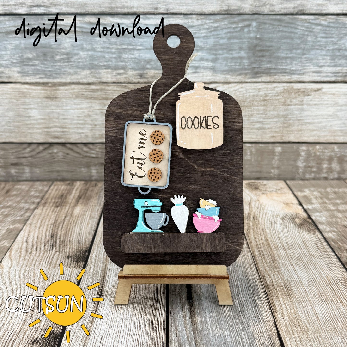A digital representation of a cutting board decor set with interchangeable cookie-themed add-ons, displayed on a wooden table with a 'digital download' text overlay.