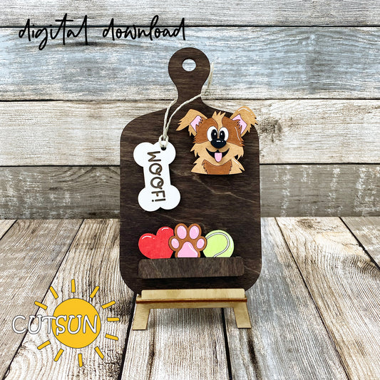 A digital download image showing a wooden cutting board decoration with a cute cartoon dog, a bone-shaped tag with the word 'WOOF', a heart, a paw print, and a tennis ball.