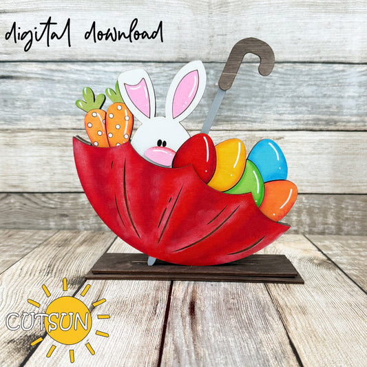 A digital download illustration of a red umbrella with a white bunny, multicolored eggs, and a polka-dot carrot, marketed as Easter shelf decor.
