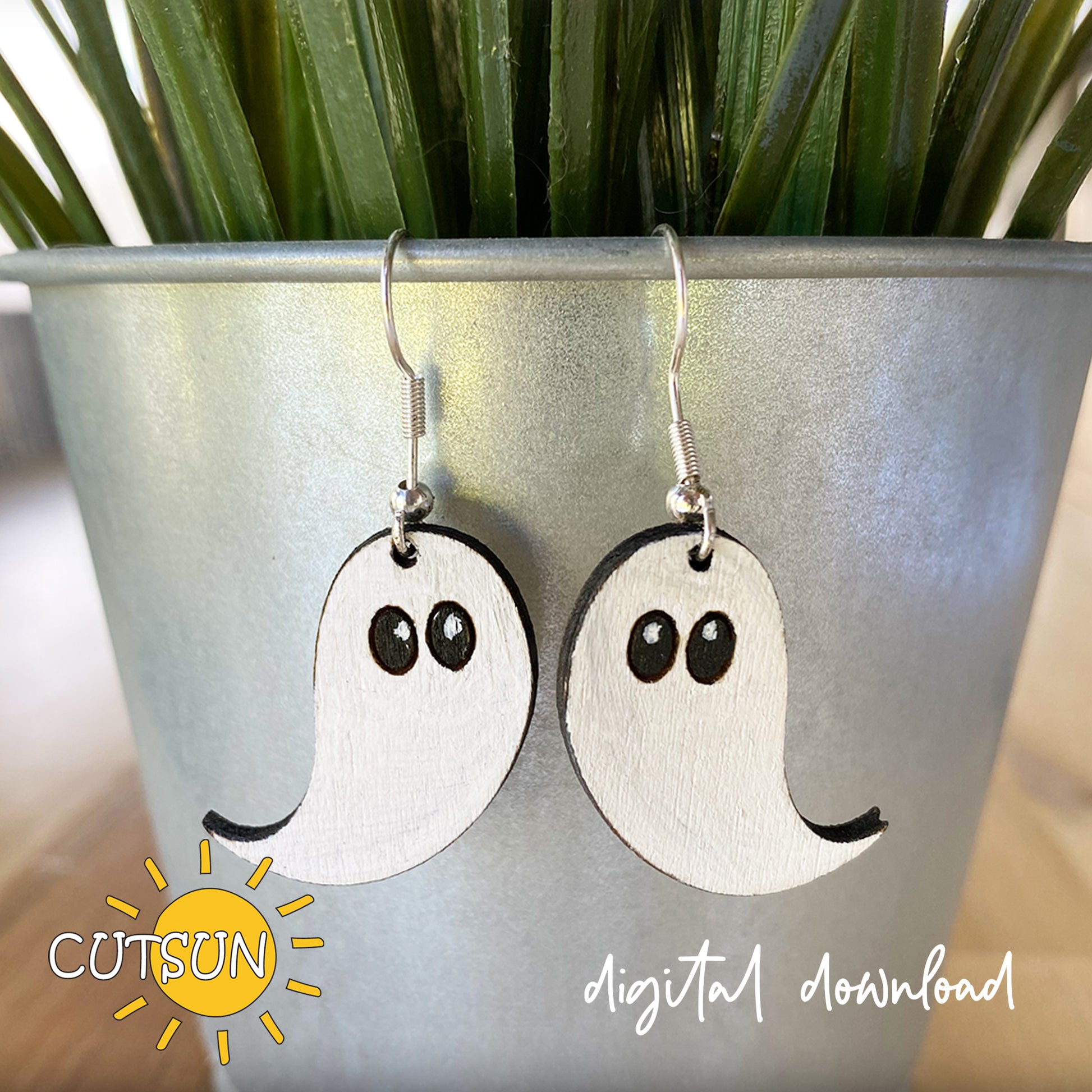A pair of ghost-shaped earrings displayed in a plant pot, indicating a digital download for the design file.
