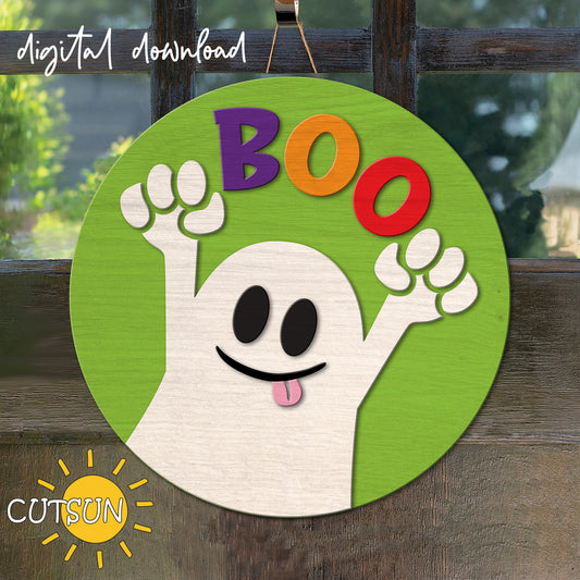 A digital illustration of a cute, cartoon-style ghost with the word 'BOO' on a green round background, indicating a Halloween-themed door hanger.