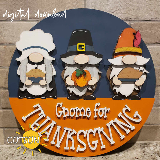 A digital image showing a round door hanger with three cartoon gnomes dressed in Pilgrim costumes, each holding a different Thanksgiving-related item, such as a pumpkin, pie, and turkey, with the text 'Gnome for Thanksgiving'.