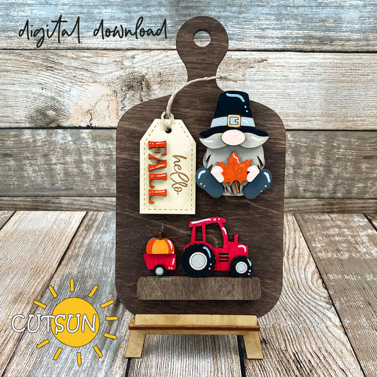 Digital download for a faux cutting board shelf sitter featuring a Pilgrim gnome, a tractor with a pumpkin and a tag with the text Hello Fall.