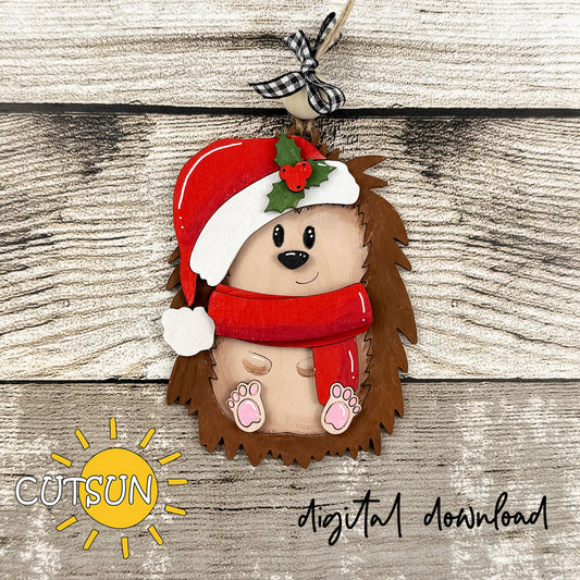 Hedgehog ornament with Santa hat and scarf on a wooden background, featuring the Cutsun brand.