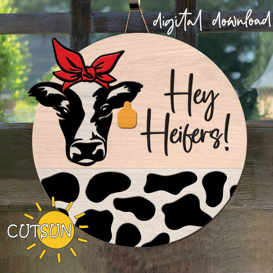 Digital download for a round door hanger featuring a cow with a bandana and a tag, cow print on the bottom half of the round and the text 'Hey Heifers!'.