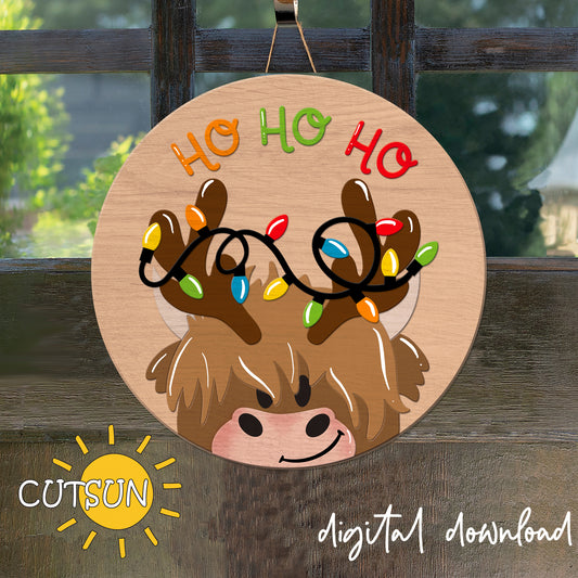 A digital door hanger featuring a cartoon highland cow with reindeer antlers and the text 'Ho Ho Ho' surrounded by Christmas lights, indicating a festive or holiday theme.