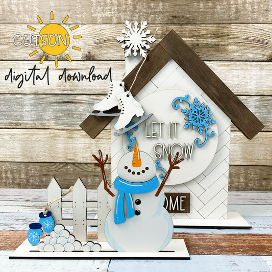 Digital download for an Interchangeable shelf sitter featuring a house and a fence with winter add-on: a snowflake, a round sign with snowflakes and text 'Let it snow', a snowman, pile of snow balls, mittens and skates.