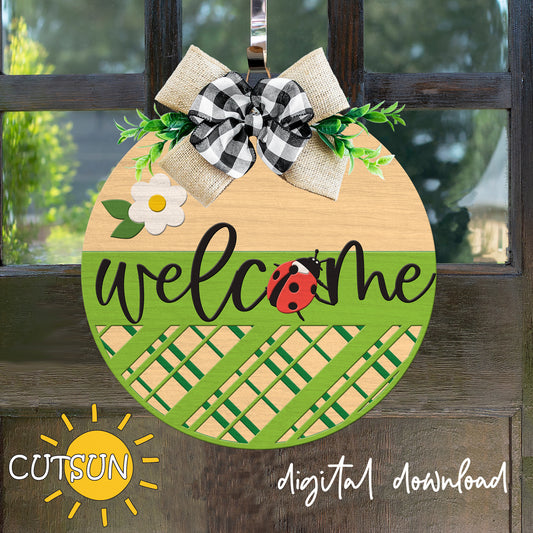 Decorative door hanger with 'welcome' text, ladybug, and checkered bow on a wooden surface.