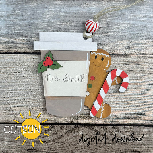 Decorative Christmas ornament with a gingerbread man, candy cane, and coffee cup on a wooden background.