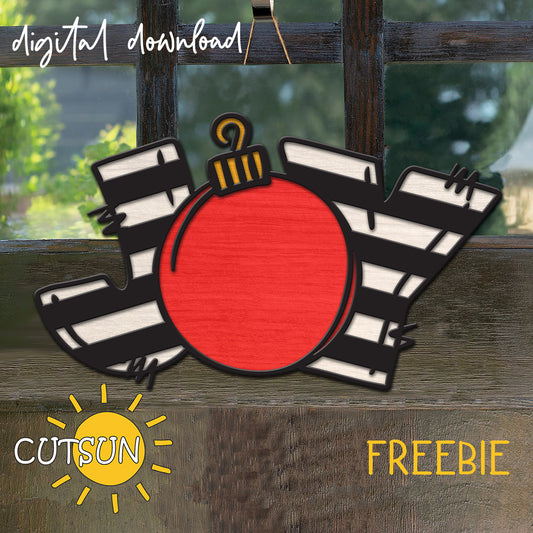 Layered JOY Christmas ornament SVG freebie for laser cutting, featuring black-and-white stripes and a red ornament.