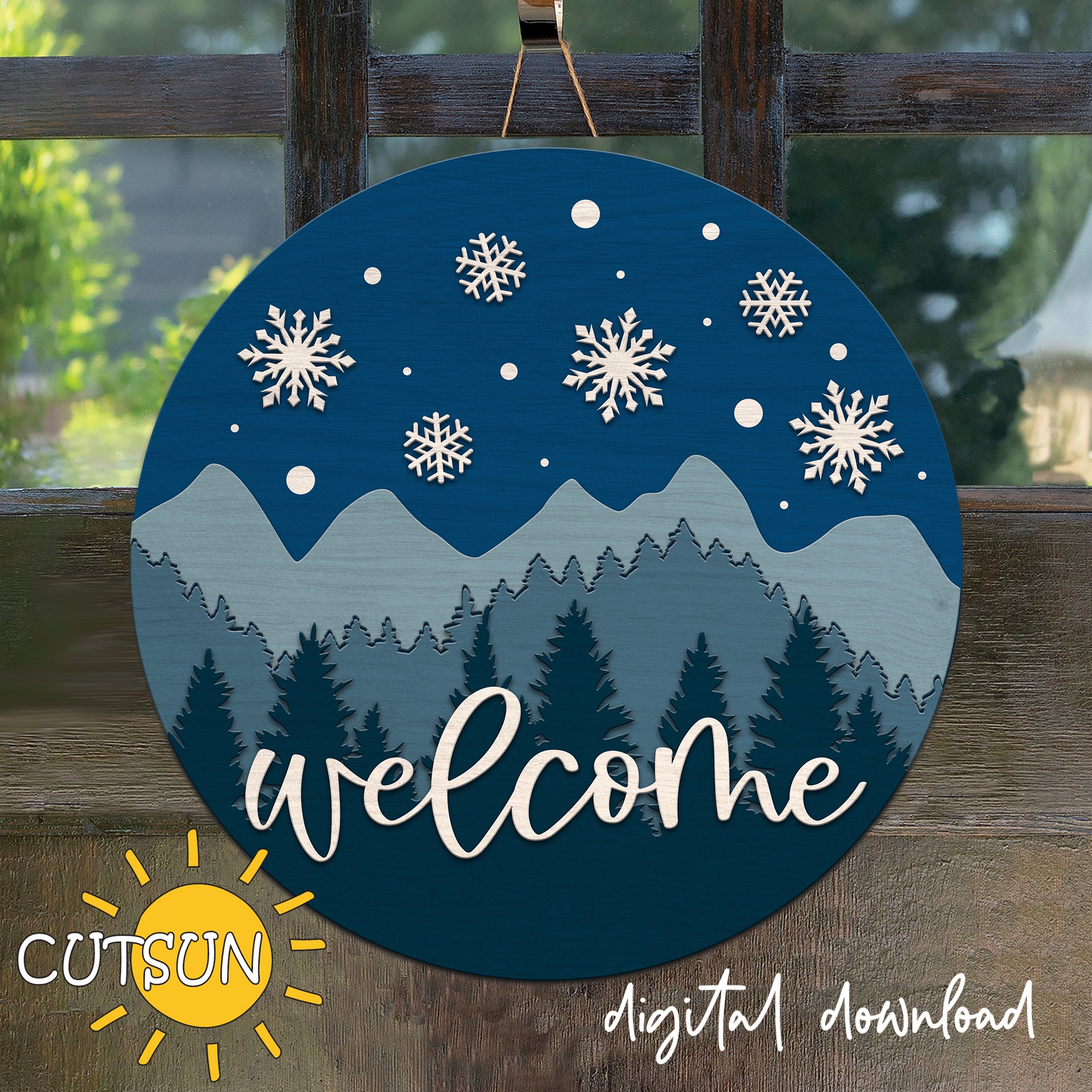 Round decorative sign with mountain and snowflake design, featuring the word 'welcome'.