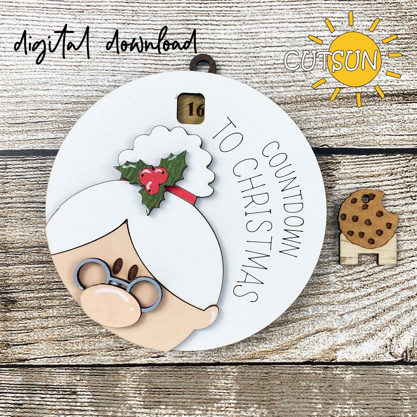 A digital download of a Christmas-themed ornament featuring a cartoon illustration of Mrs. Santa with glasses and a bun, with the text 'Countdown to Christmas' and a small cookie figure.