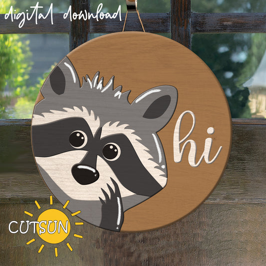 A digital image showing a circular door hanger with a laser cut design of a raccoon peeking out from behind it, with the text 'Raccoon Hi' and 'CUTSUNSG' visible.