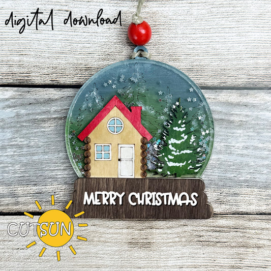 “Layered snow globe Christmas ornament with cozy cabin, evergreen trees, glitter ‘snow,’ and a wooden base reading ‘Merry Christmas’—laser-cut, hand-painted sample.”