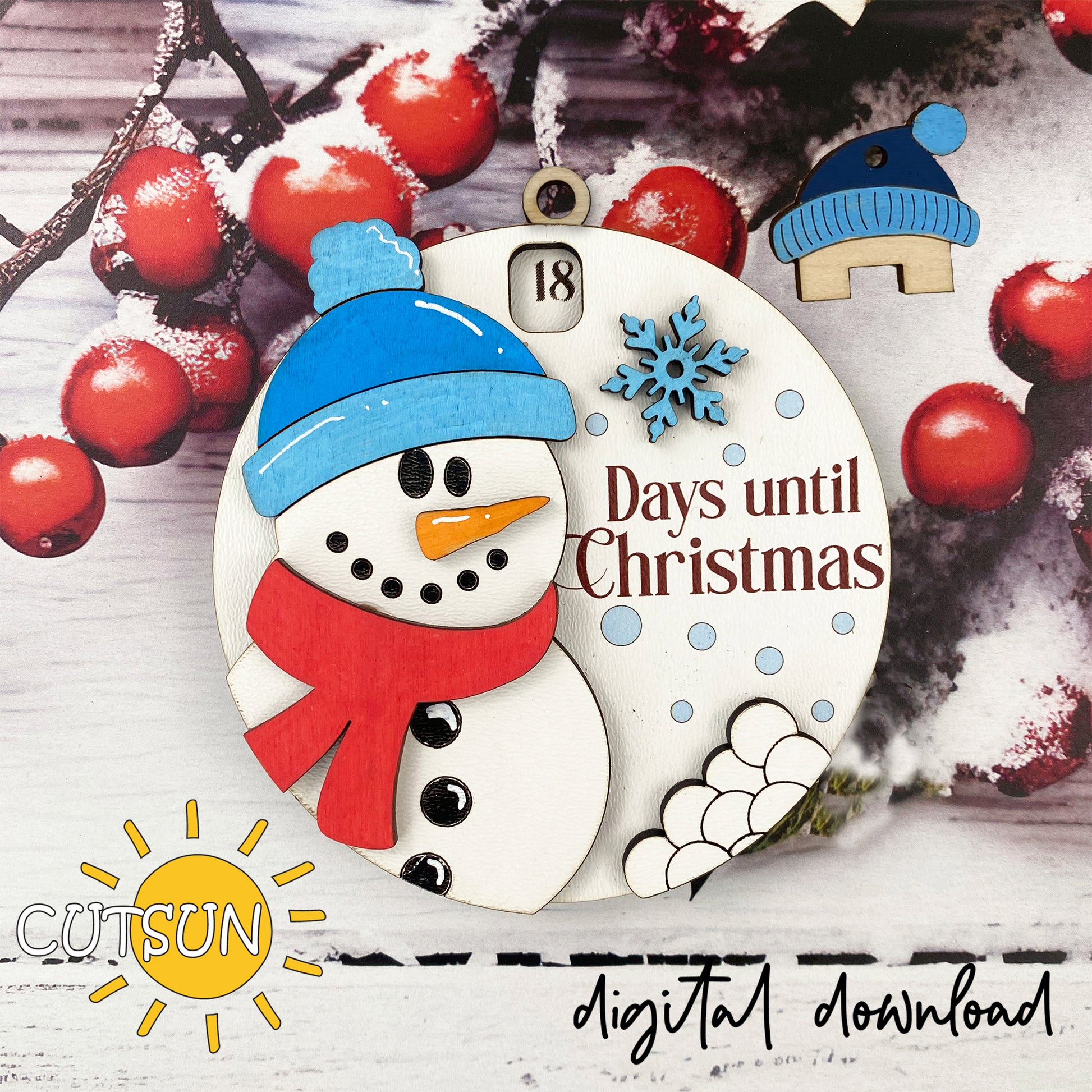 A digital download image of a circular Christmas ornament featuring a snowman, a pom-pom hat, and the text '18 DAYS UNTIL CHRISTMAS' with a small house icon. There is also a countdown wheel visible at the top.
