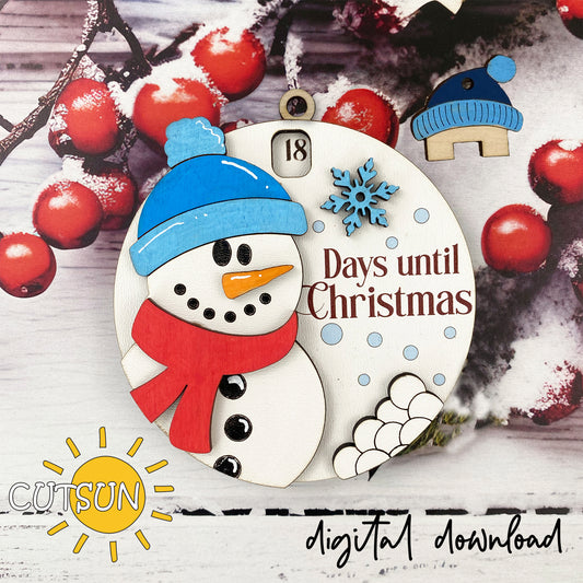 A digital download image of a circular Christmas ornament featuring a snowman, a pom-pom hat, and the text '18 DAYS UNTIL CHRISTMAS' with a small house icon. There is also a countdown wheel visible at the top.