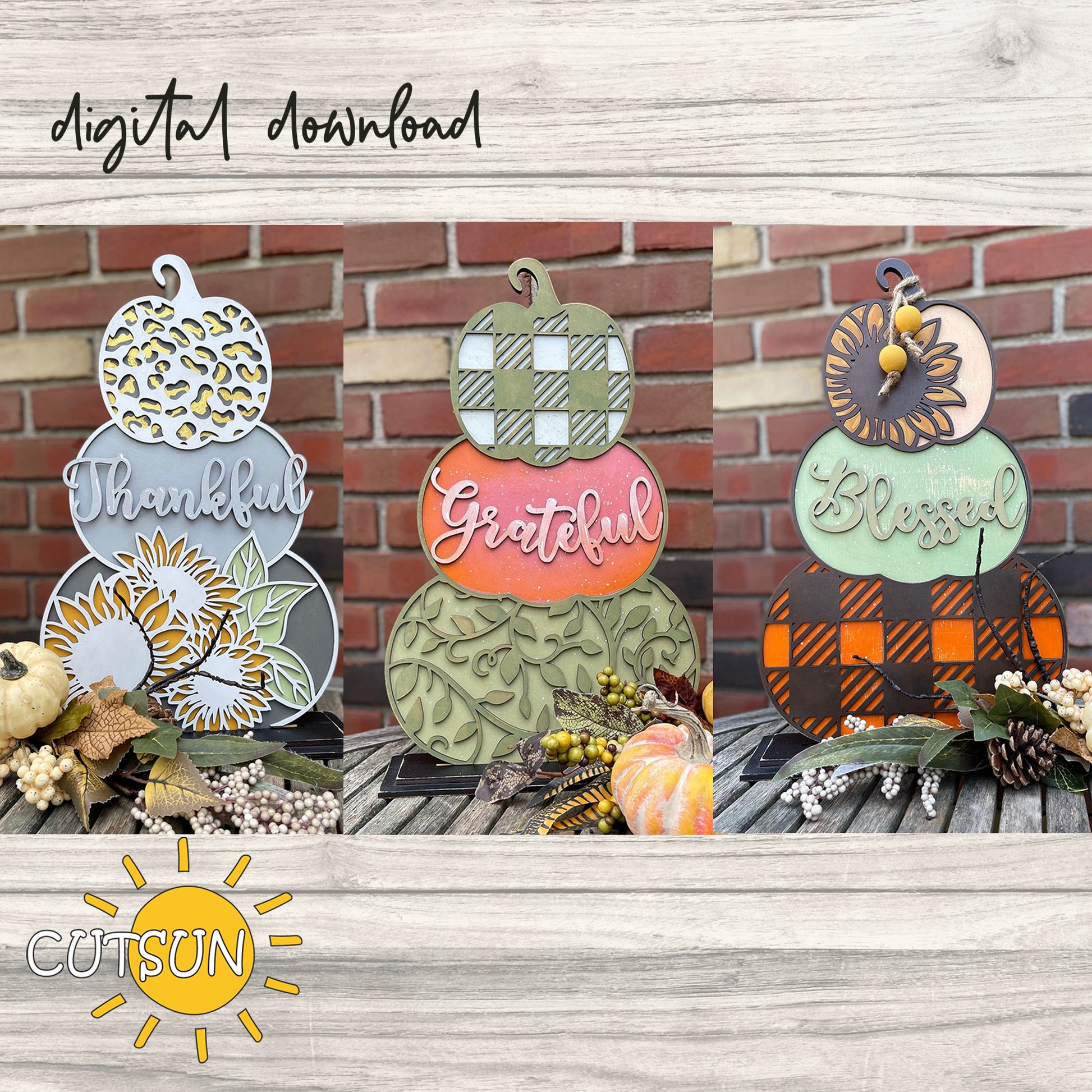 Three patterned pumpkin-shaped decorations with the text 'THANKFUL', 'GRATEFUL', and 'BLESSFUL' on a wooden surface, surrounded by autumn decorations like leaves and pumpkins.