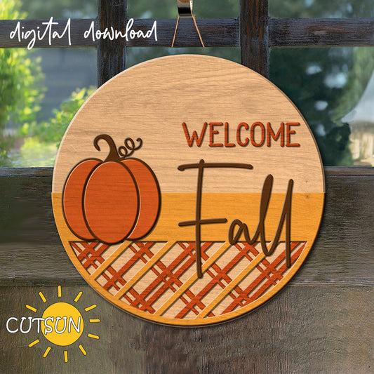 A digital download of a circular door hanger with a pumpkin and a patterned bottom in plaid, with text 'Welcome Fall'.