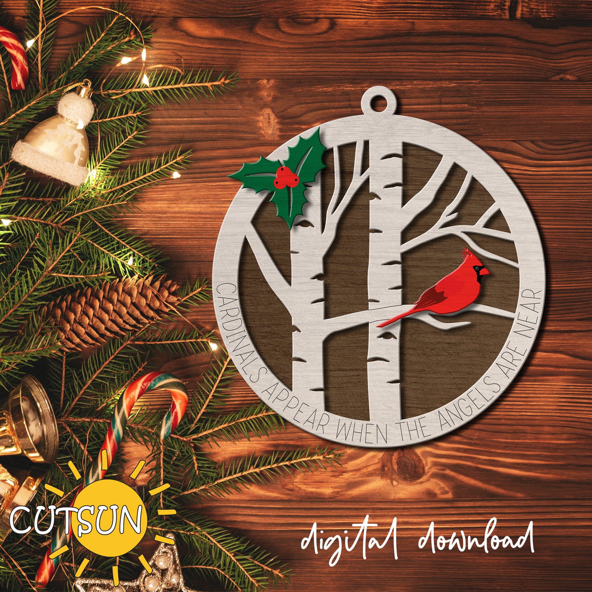 Decorative metal ornament with a tree and cardinal design on a wooden background with Christmas decorations.