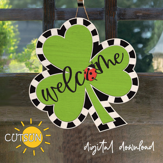 Decorative shamrock with 'welcome' text and ladybug on a wooden background, featuring the brand 'CUTSUN'.