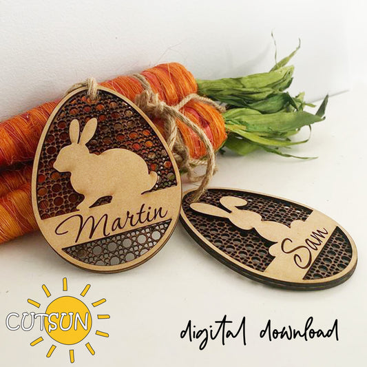 Two wooden Easter egg-shaped ornaments with rabbit silhouettes and names 'Martin' and 'Sam', tied together with twine, on a white background.