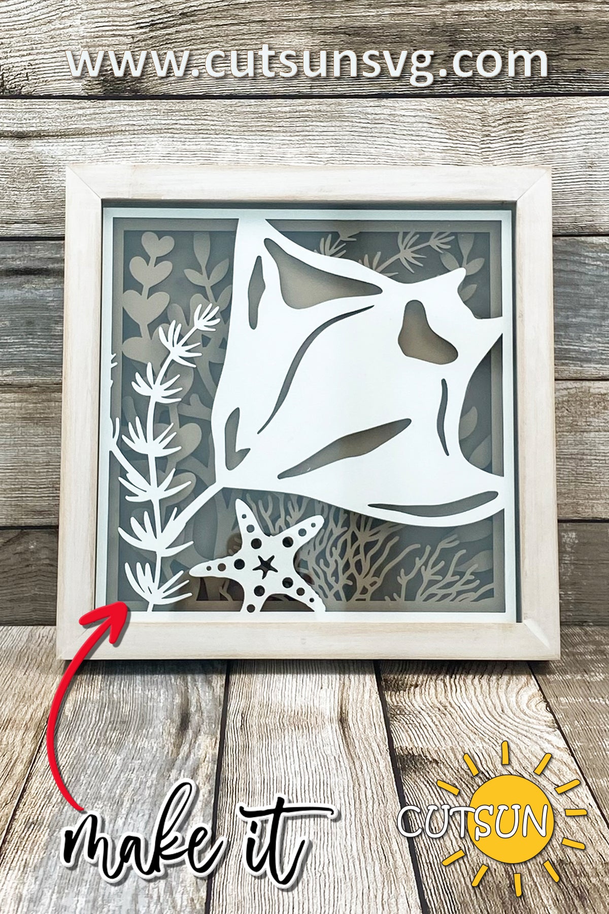 Layered shadow box design featuring a manta ray swimming among coral, seaweed, and a starfish, displayed in a wood frame.