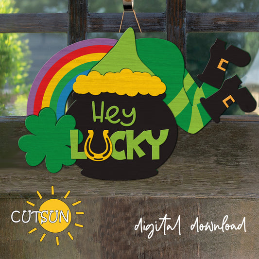 Decorative sign with rainbow, pot of gold, and clover on a wooden surface with 'CUTSUN' branding.