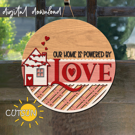 Decorative sign with 'Our Home is Powered by Love' text on a wooden background