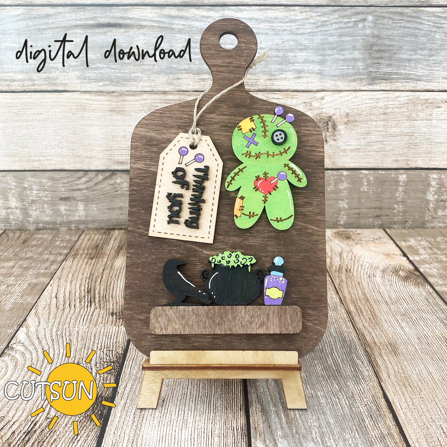 A digital download image showing a wooden cutting board decorated with a Voodoo doll, a raven, a cauldron, a potion bottle, and a tag with the words 'Thinking of you'.