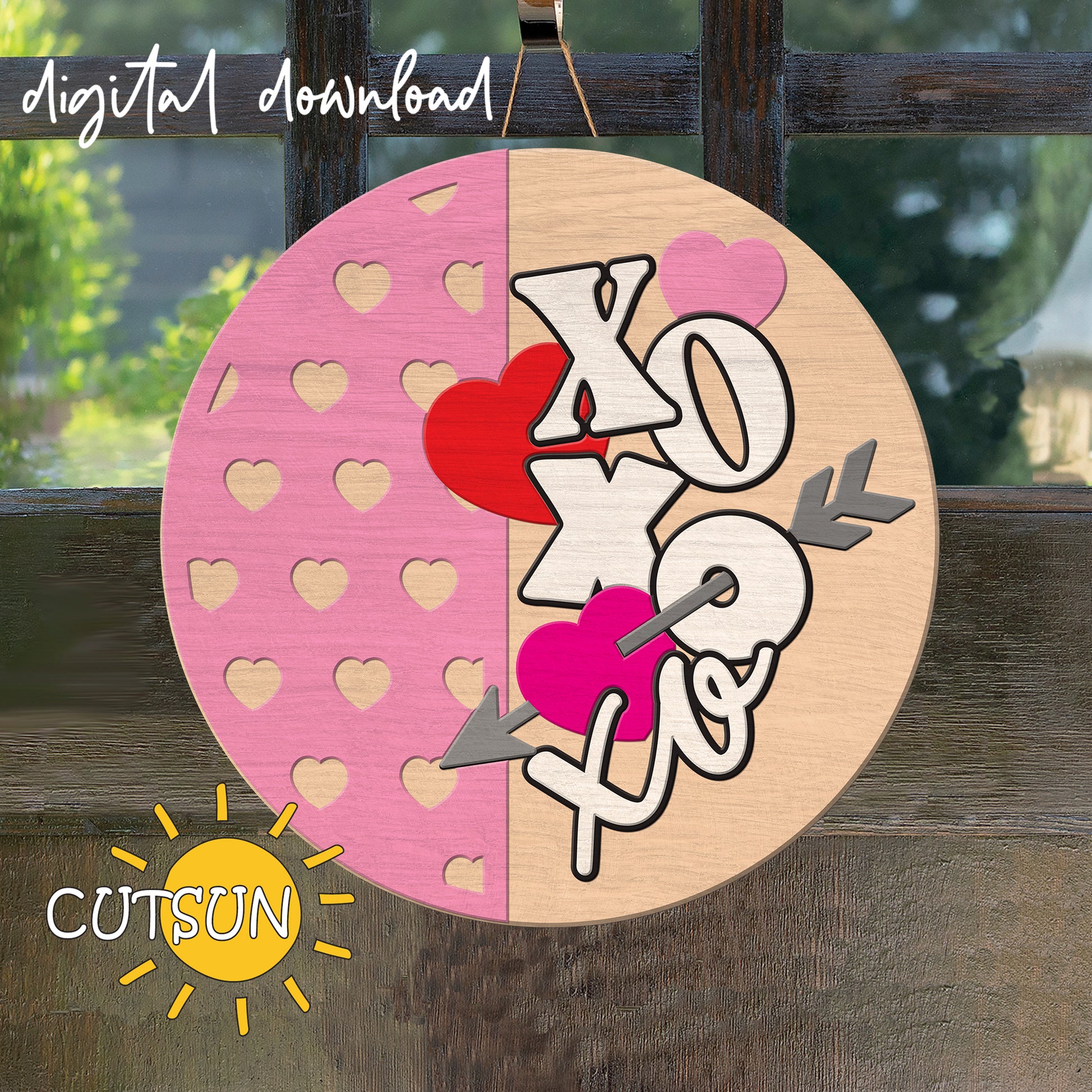 Circular wooden cutout with 'XO' and heart designs on a pink and beige background, with 'CUTSUN' logo.