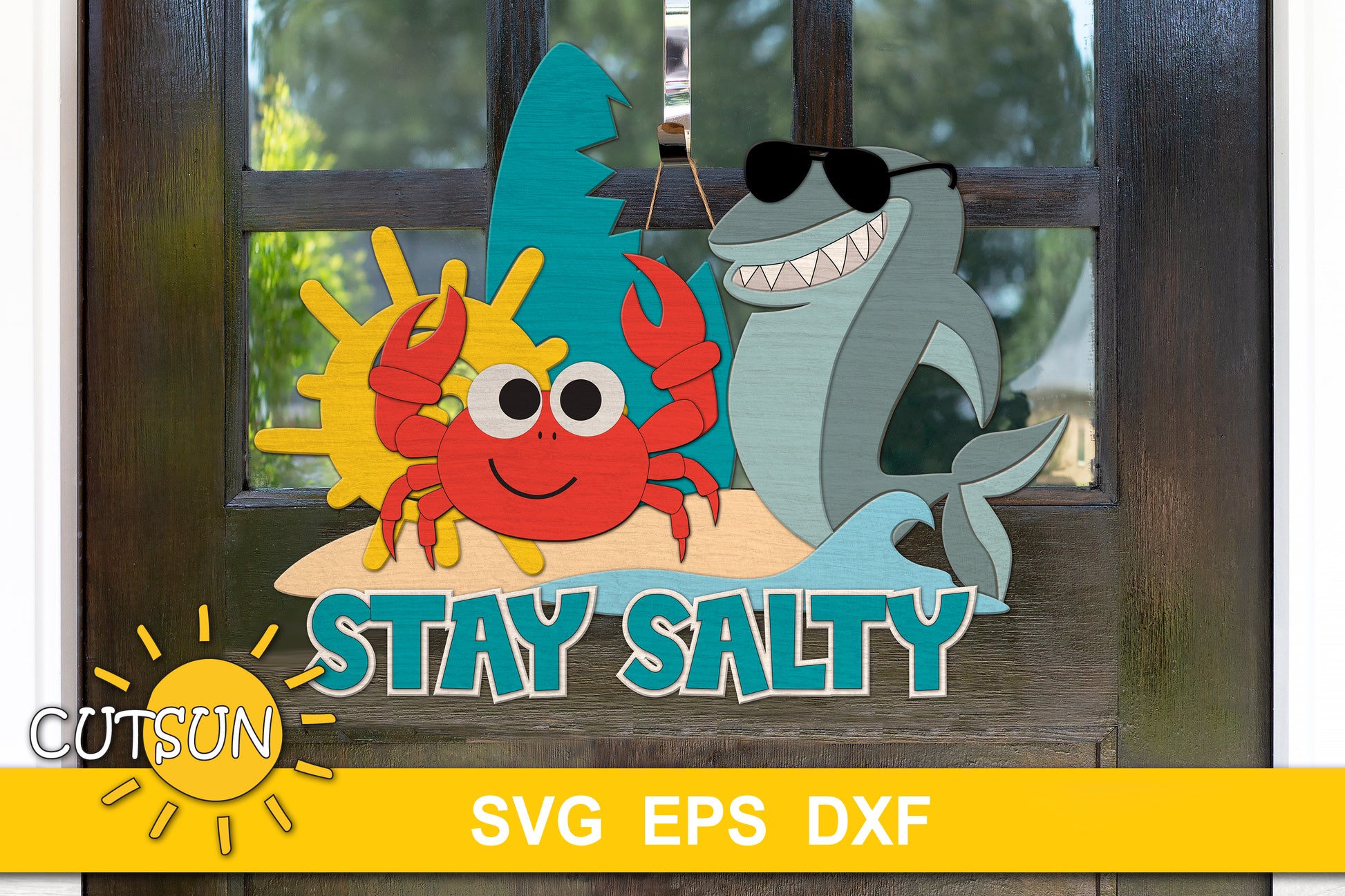 Layered wood door sign with the phrase “Stay Salty,” featuring a smiling red crab, a sunglasses-wearing shark, sun, wave, and beach scene.