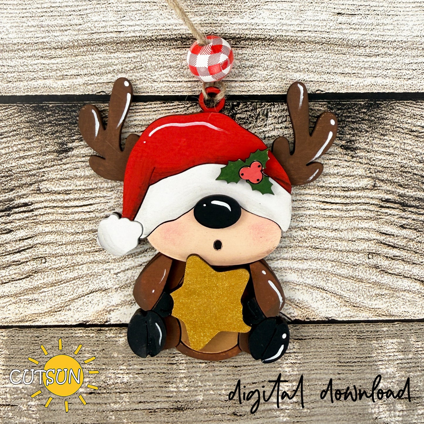 A Christmas-themed ornament featuring a cute cartoon reindeer wearing a red Santa hat with white trim, brown antlers, a red and white checkered hanging loop, and a glittery gold star. The ornament is displayed against a rustic wood plank background with 'CUTSON' and 'digital download' text overlays.