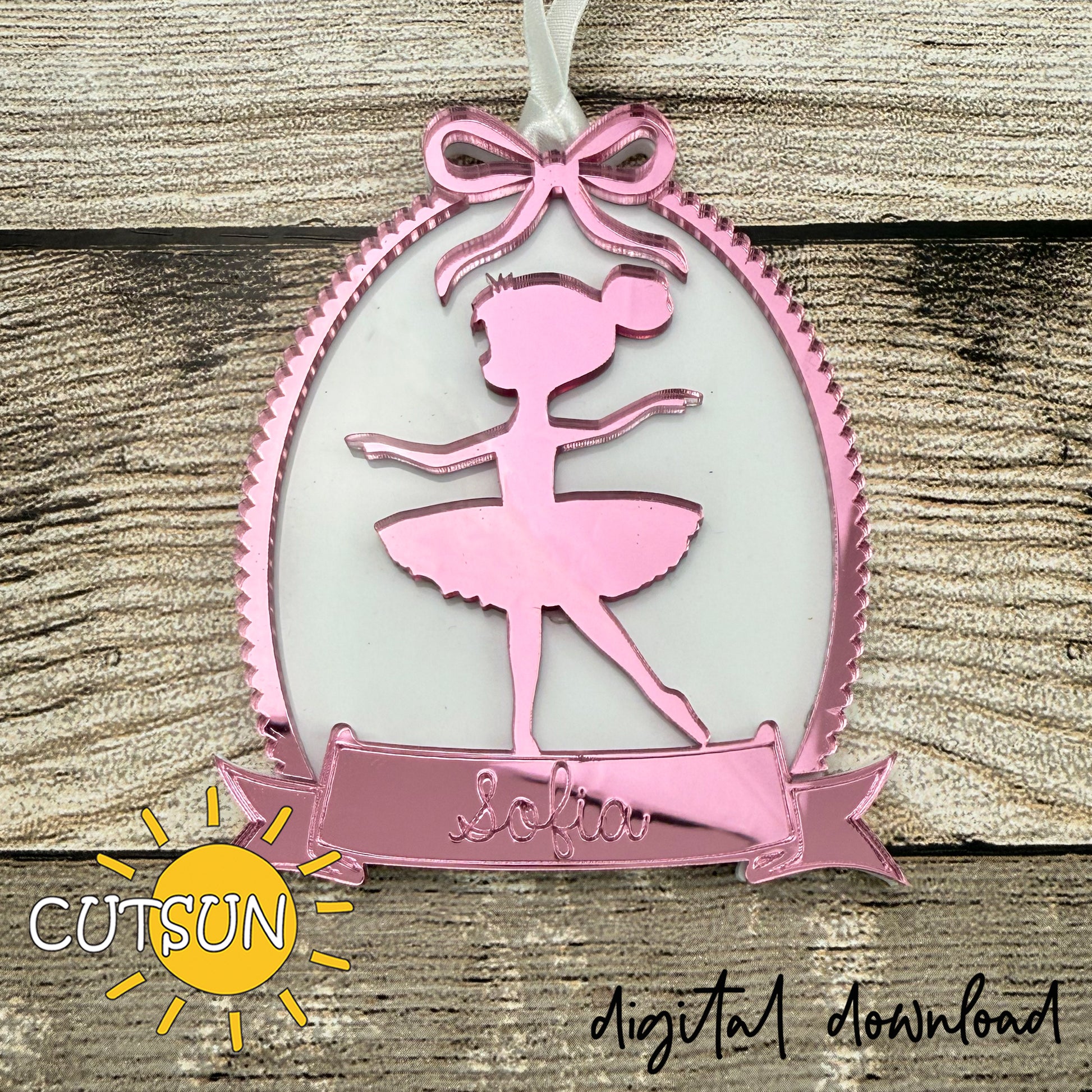 Pink ballerina ornament with ribbon frame and personalized name banner, designed for laser cutting.
