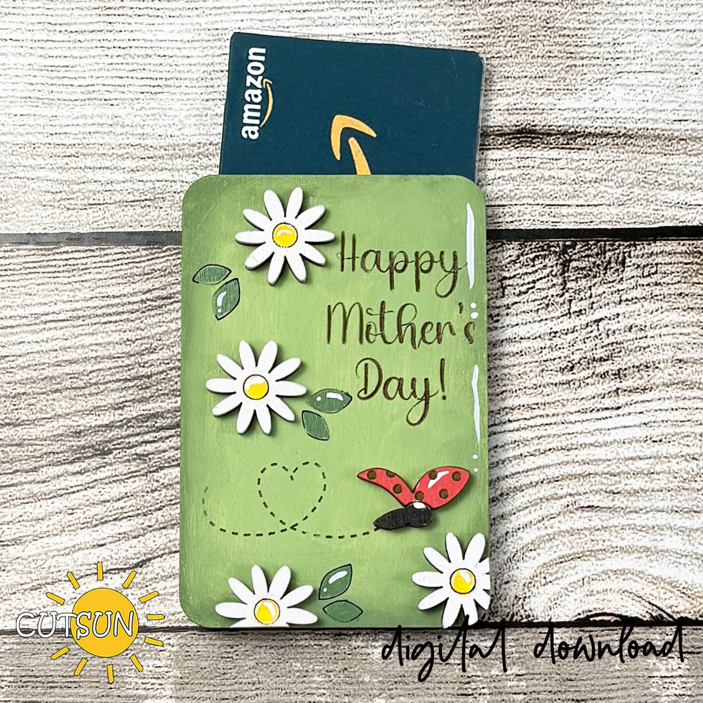 Mother's Day gift card holder with daisies and a ladybug on a wooden surface, featuring an Amazon gift card.