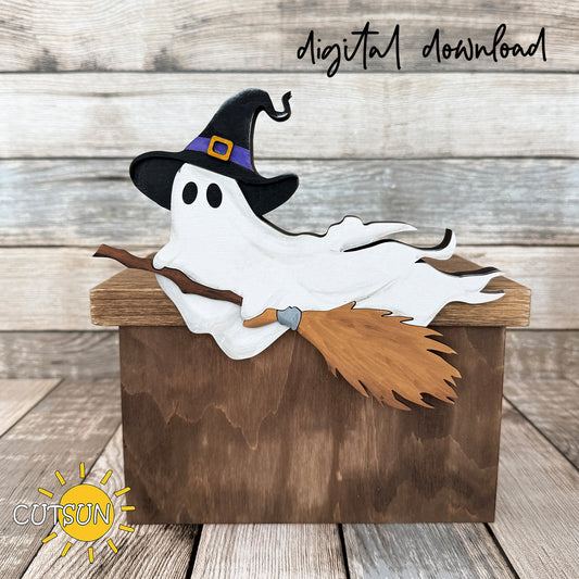 Layered wooden Halloween ghost wearing a witch hat and flying on a broom along the edge of a shelf.