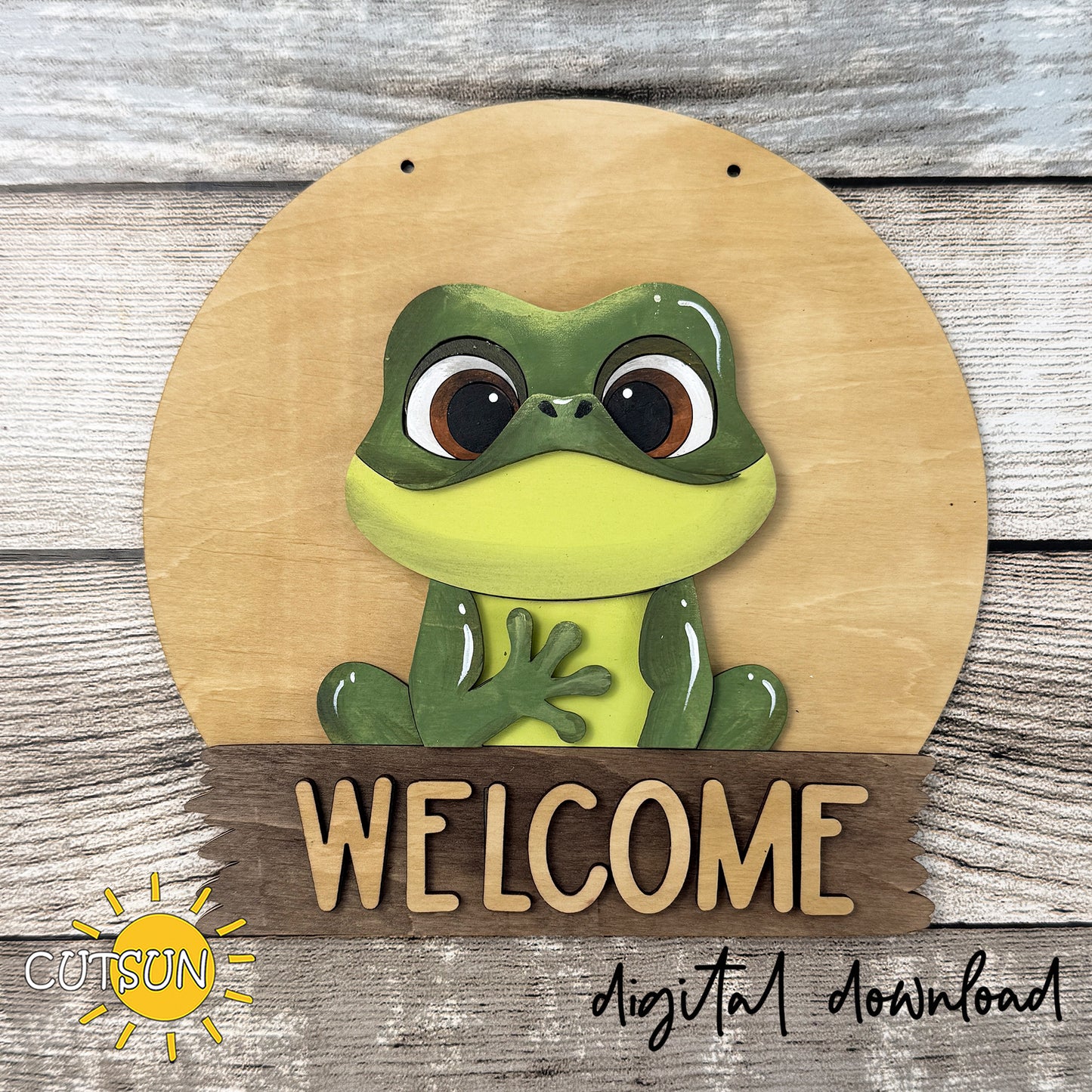 Layered frog door hanger SVG featuring a cute frog sitting on a round welcome sign, interchangeable laser cut file for seasonal front door decor.