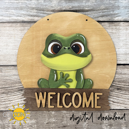 Layered frog door hanger SVG featuring a cute frog sitting on a round welcome sign, interchangeable laser cut file for seasonal front door decor.