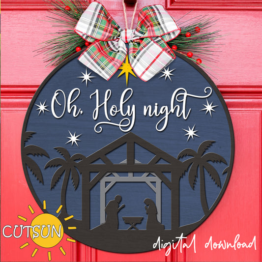 Decorative Christmas ornament with 'Oh Holy Night' text and nativity scene on a blue background, featuring a bow and festive elements.