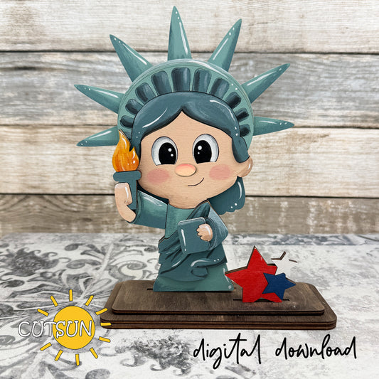 Layered wooden Liberty Girl shelf sitter with Statue of Liberty crown, torch, and patriotic stars on a rectangular stand for laser cut decor

