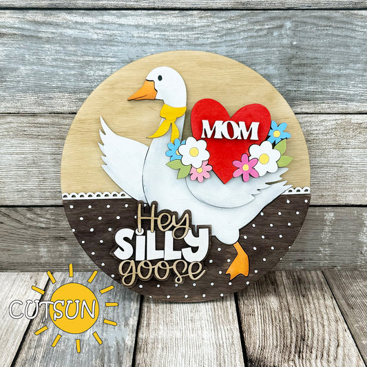 Laser-cut Mother’s Day goose sign add-on featuring a red heart with “MOM” text and colorful spring flowers