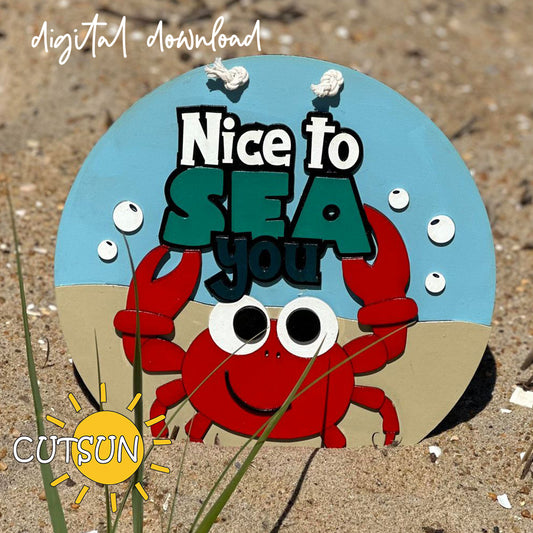 Layered laser cut beach sign with a smiling red crab holding up the phrase “Nice to SEA You” on a blue and sand background.