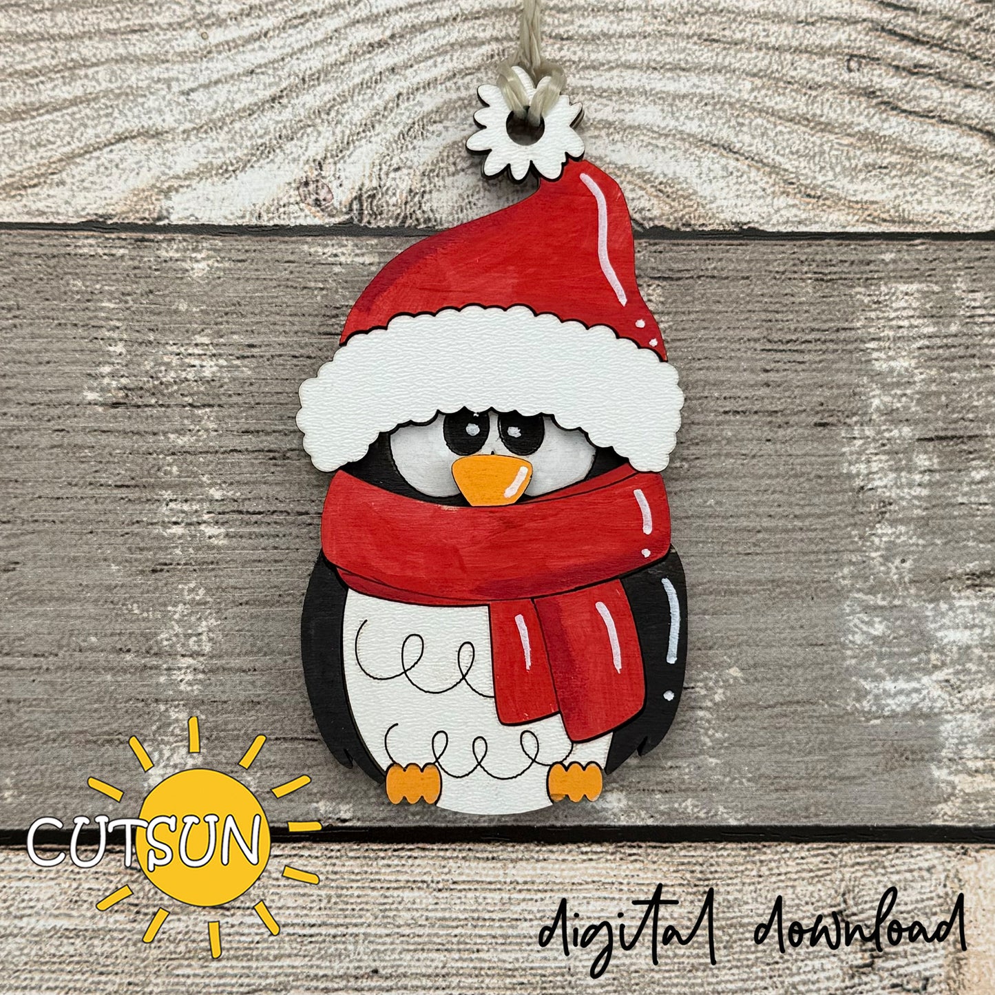 Decorative penguin ornament with a red hat and scarf on a wooden background, featuring the Cutsun brand.